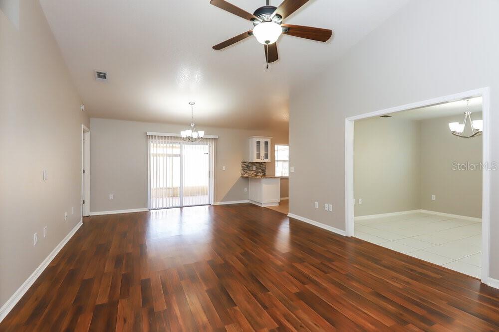An open-concept living area features dark wood flooring, a ceiling fan, and a tiled dining space — 213 LOOKOUT DRIVE, APOLLO BEACH, FL