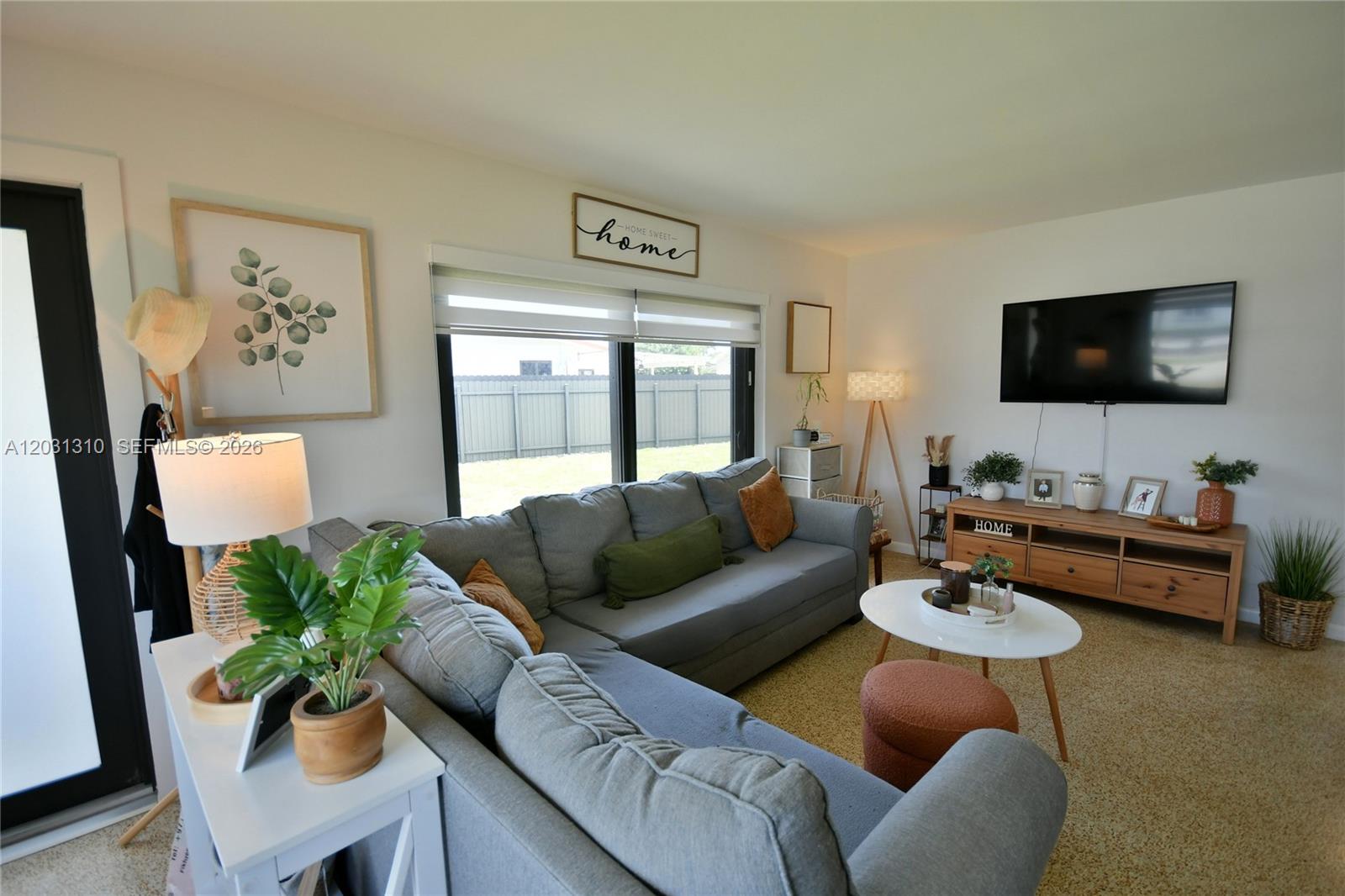 A living room features a gray sectional sofa, a television, and a wooden media console — 8350 SW 12th Ter, Miami FL 33144, MIAMI, FL