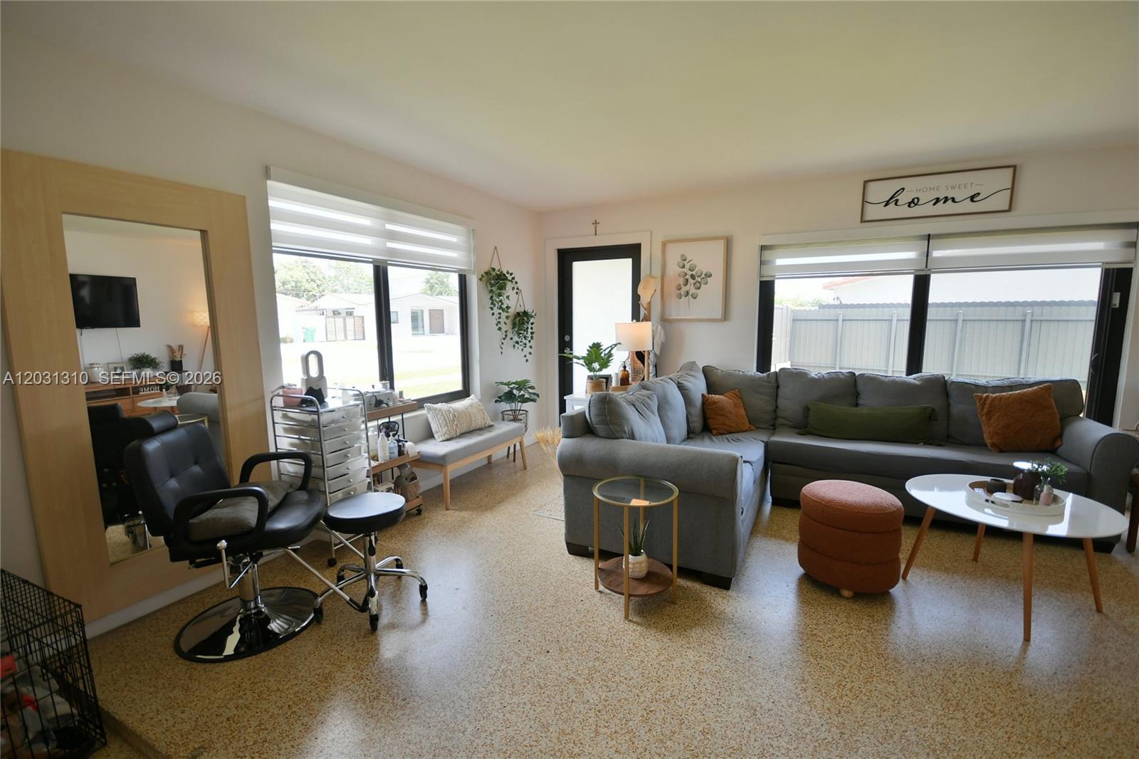 A living room features a grey sectional sofa, a salon chair, and speckled flooring — 8350 SW 12th Ter, Miami FL 33144, MIAMI, FL