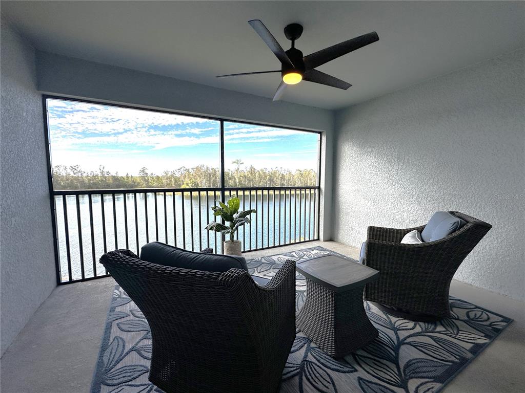 A covered balcony features two wicker chairs, a small table, and a view of water — 14241 HERITAGE LANDING BOULEVARD UNIT 1821, PUNTA GORDA, FL
