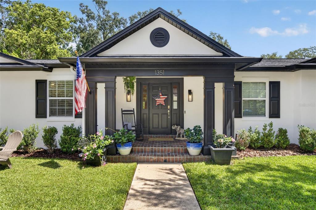 A single-story house with a white exterior, black shutters, and a covered front porch — 1351 ONECO AVENUE, WINTER PARK, FL