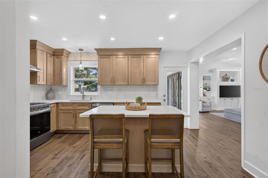A kitchen with light wood cabinets, a white island, and wood-look flooring — 1351 ONECO AVENUE, WINTER PARK, FL