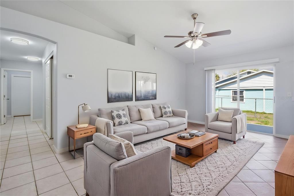 A living room features a gray sofa, two armchairs, a wooden coffee table, and tile flooring — 6018 FLORA TERRACE, APOLLO BEACH, FL