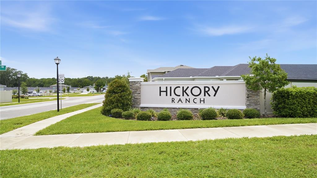 A stone and stucco monument sign for Hickory Ranch stands beside a residential street — 707 CHESTNUT LANE, AUBURNDALE, FL