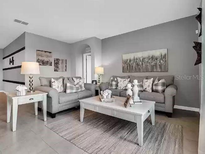 A living room features gray walls, two gray sofas, a white coffee table, and side table — 3820 SWANFALLS TERRACE, SANFORD, FL