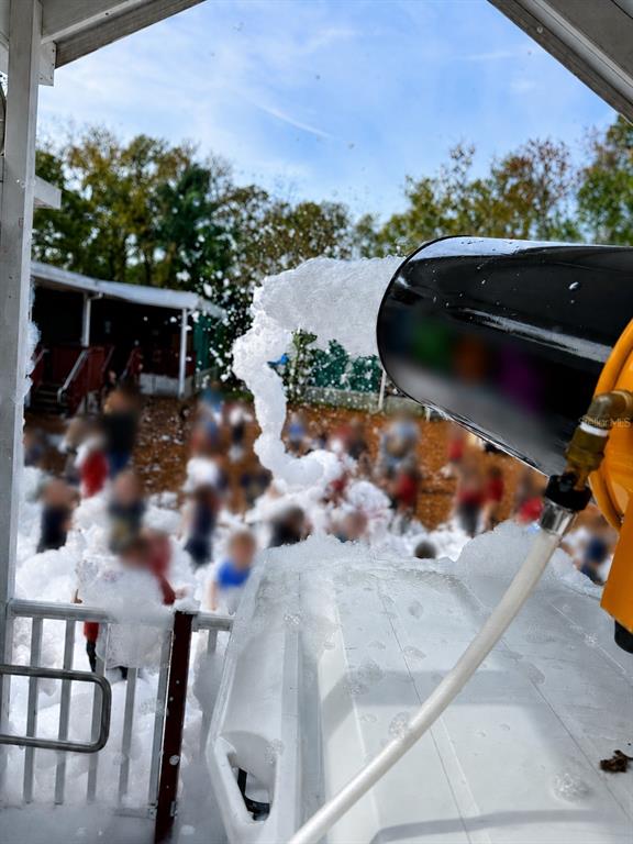 A foam machine sprays bubbles over a group of people in an outdoor play area — N/A N/A, OCALA, FL