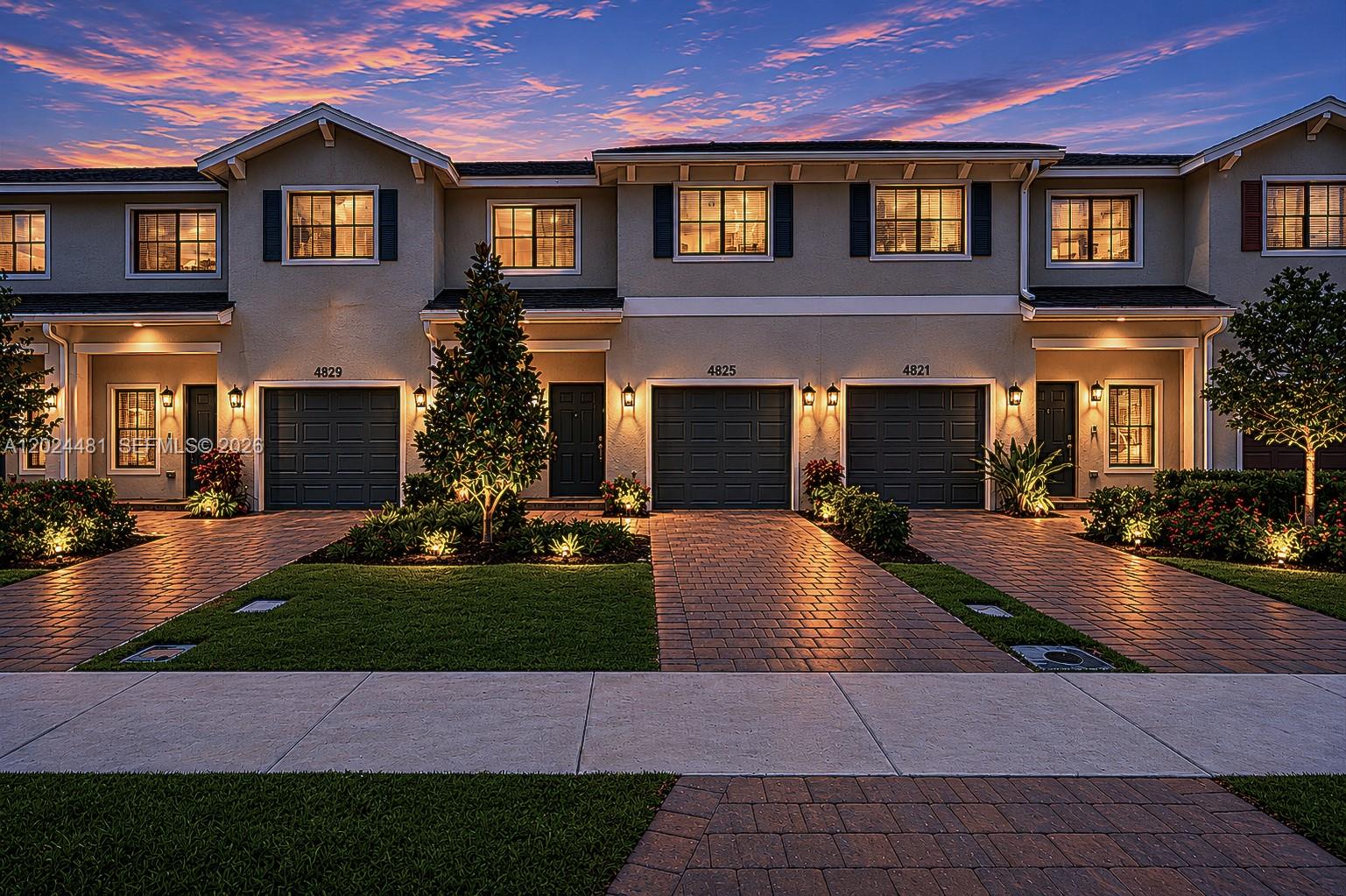 A row of three townhouses with brick driveways and illuminated windows at dusk — 4825 Dillion St, Lake Worth FL 33463, LAKE WORTH, FL