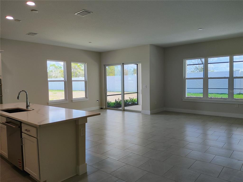 A kitchen island with a sink overlooks an open living area with large windows — 776 ANEGADA LANE, SARASOTA, FL