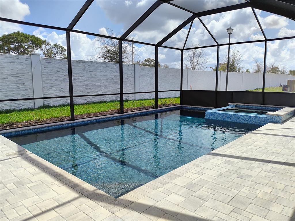 A rectangular swimming pool and attached spa are enclosed within a screened-in patio area — 776 ANEGADA LANE, SARASOTA, FL