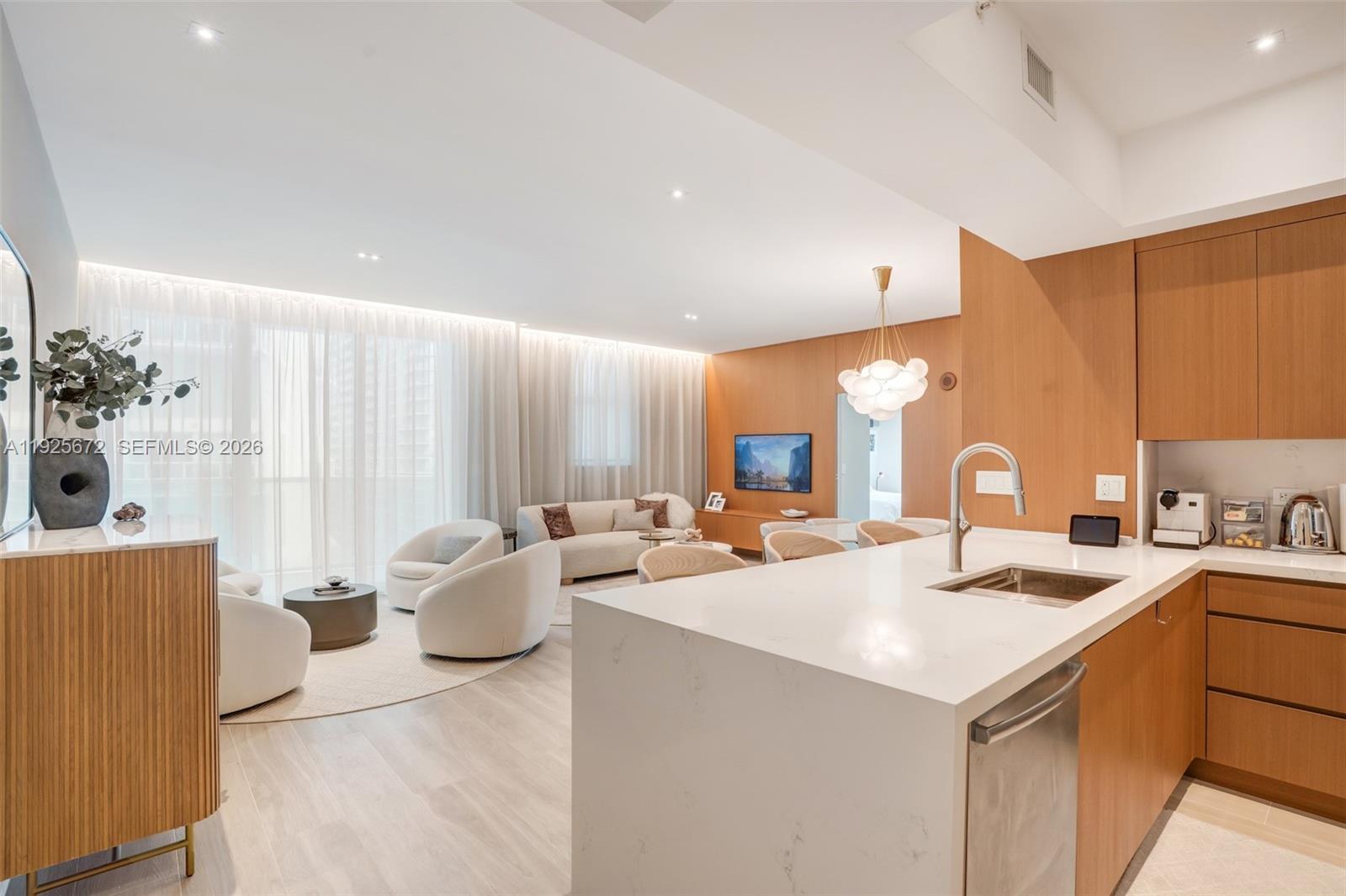 A modern living and dining area features a marble table, curved sofa, and globe chandelier — 31 SE 5th St # 3921, Miami FL 33131, MIAMI, FL
