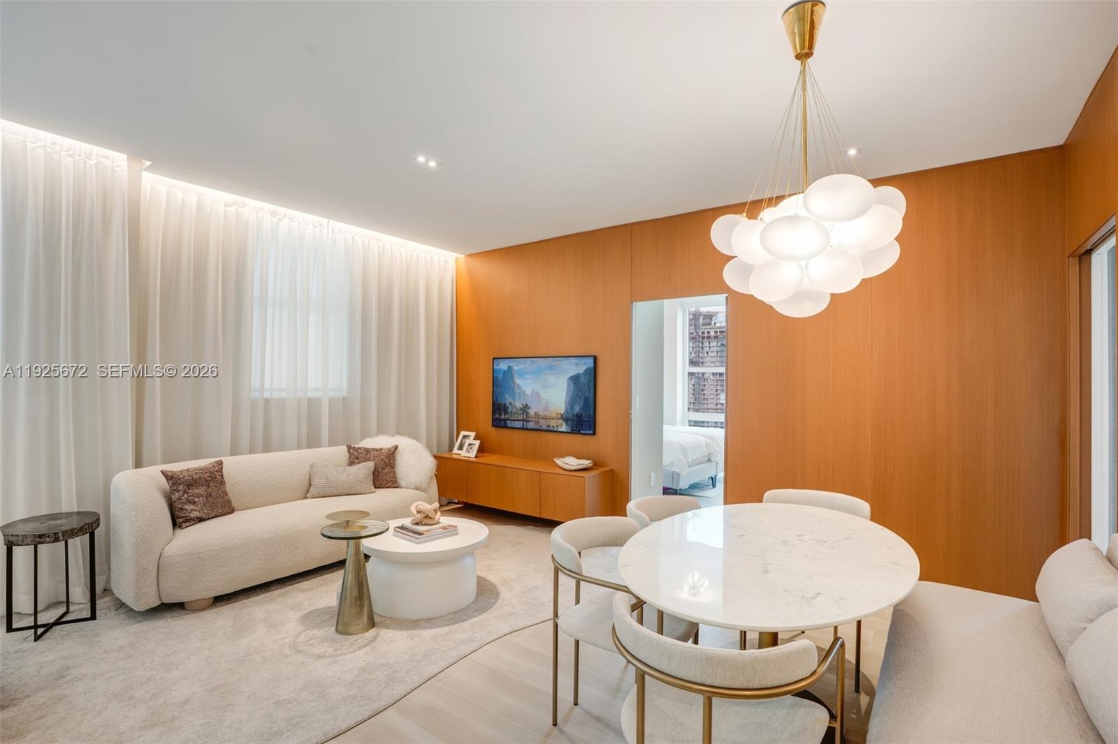 A modern open-concept kitchen and living area with light wood cabinetry and white countertops — 31 SE 5th St # 3921, Miami FL 33131, MIAMI, FL