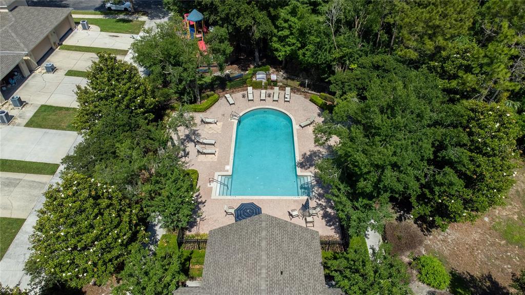 An aerial view shows a swimming pool with lounge chairs and a playground nearby — 13759 GOLDEN RUSSET DRIVE, WINTER GARDEN, FL