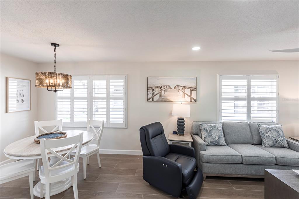 A dining area and living space feature a round table, recliner, and gray sofa — 6020 MIDNIGHT PASS ROAD UNIT 29, SARASOTA, FL