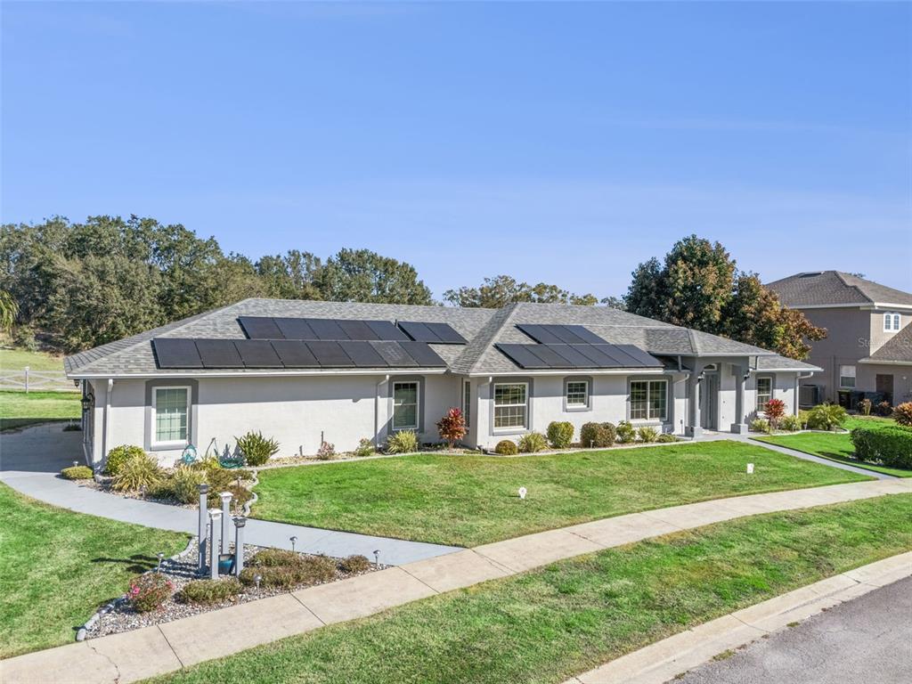 A single-story house with a gray exterior and solar panels on the roof — 217 KENT COURT, HAINES CITY, FL