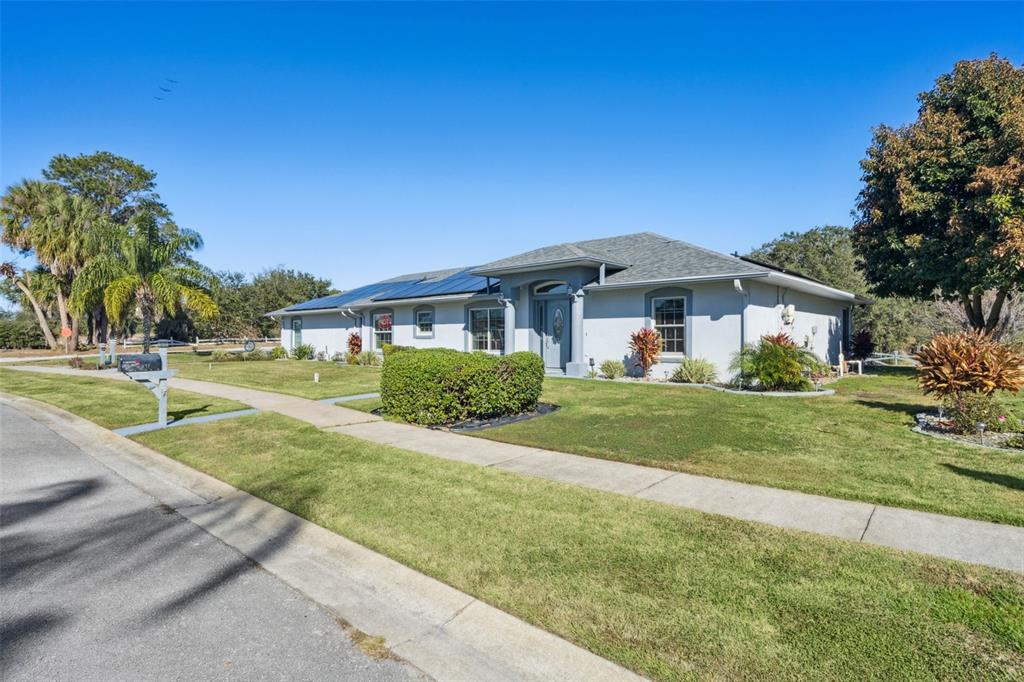 A single-story house with a gray exterior, solar panels, and a manicured lawn — 217 KENT COURT, HAINES CITY, FL