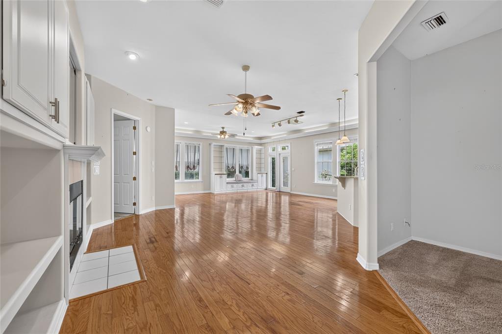 A spacious living area features hardwood floors, a fireplace, built-in shelving, and a ceiling fan — 4588 NE 4TH STREET, OCALA, FL