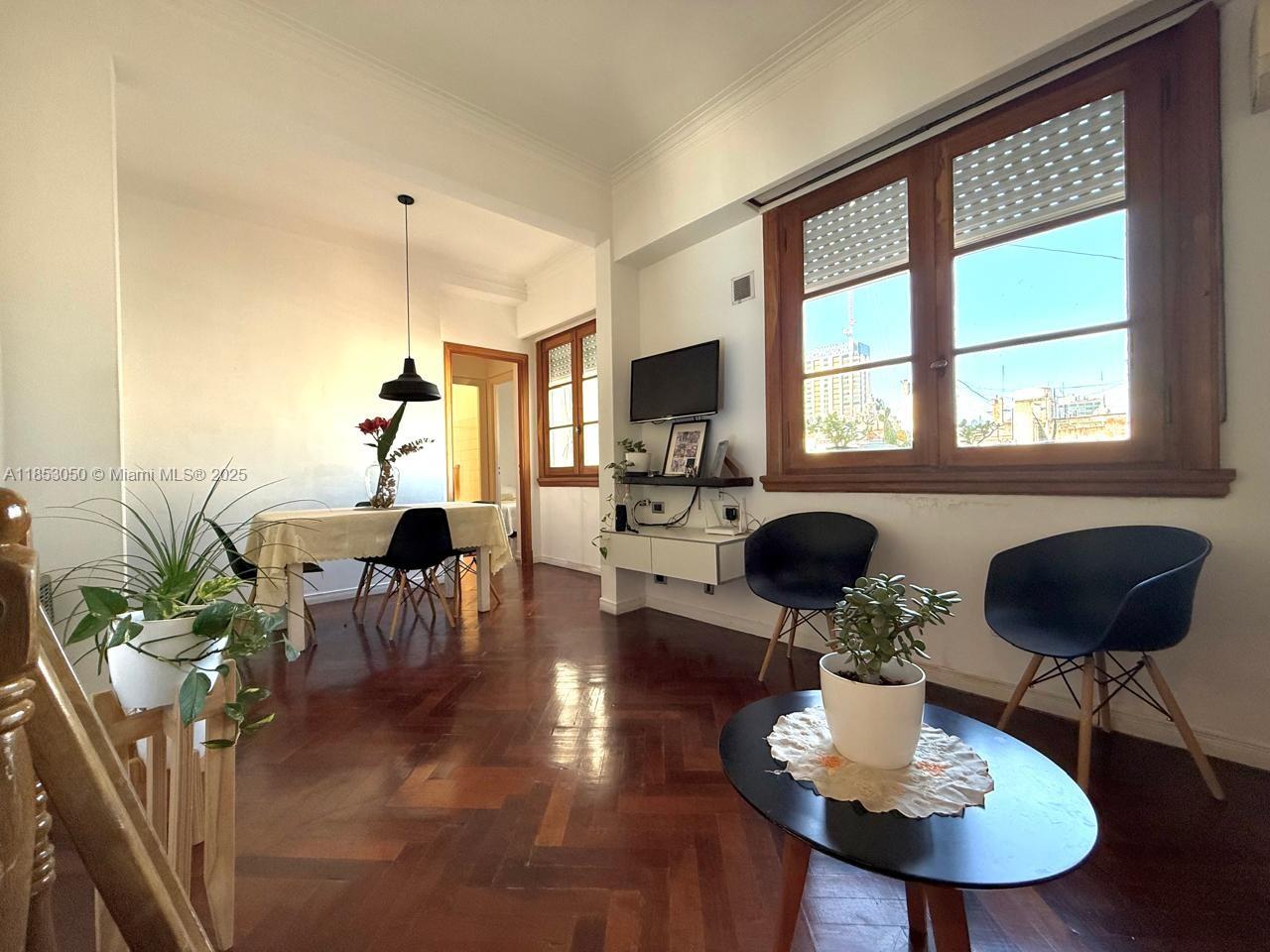 A living and dining area features hardwood floors, a wooden window, and modern furniture — 128 Bernardo de Irigoyen Montserrat # 7, FL 128, FL