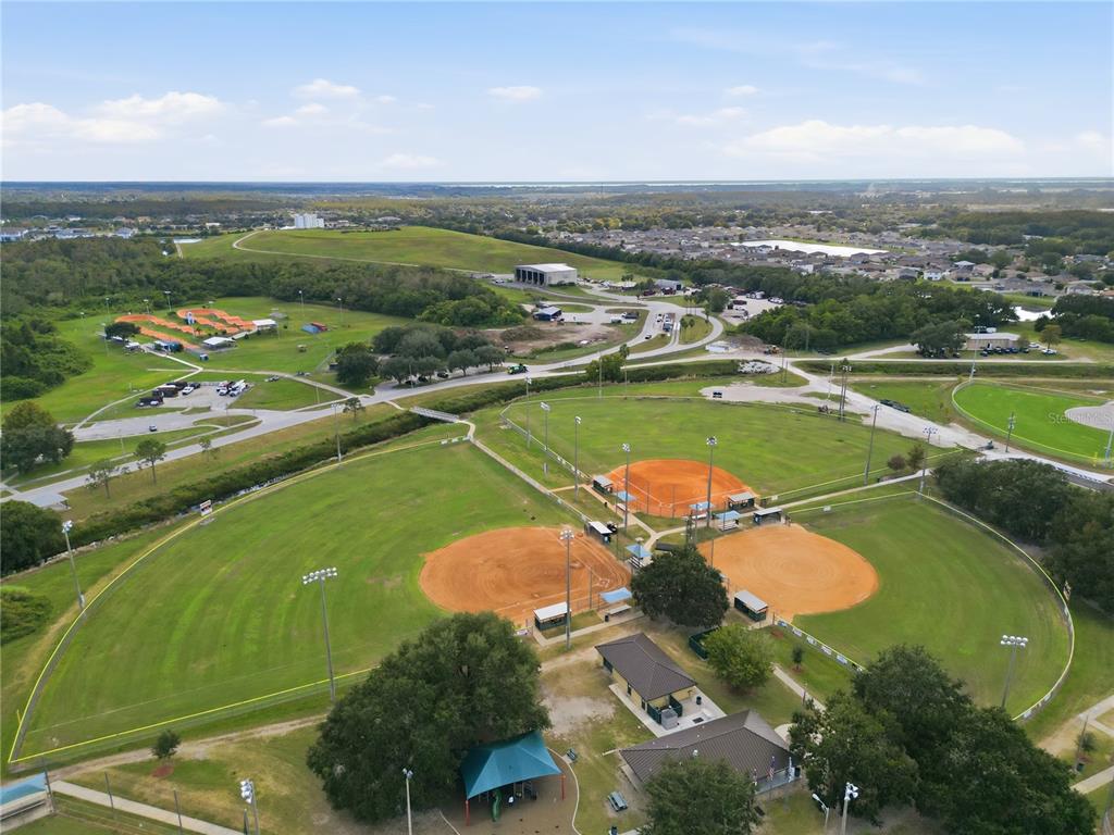 An aerial view shows a public park with three baseball fields and a playground — 5027 ORINOCO LANE, ST CLOUD, FL