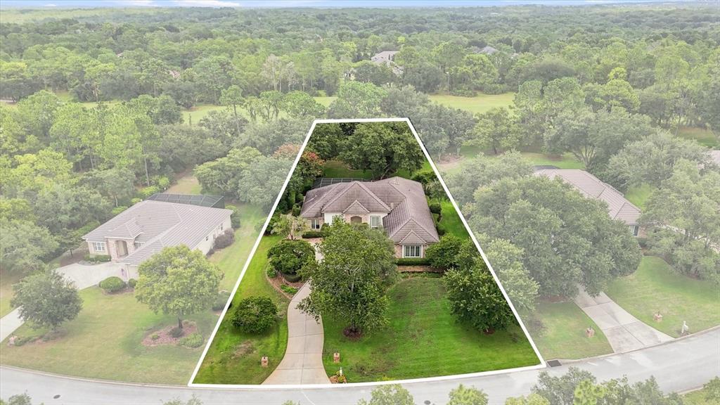 An aerial view shows a single-story house with a tiled roof on a large lot — 3405 N SPYGLASS VILLAGE PATH, LECANTO, FL