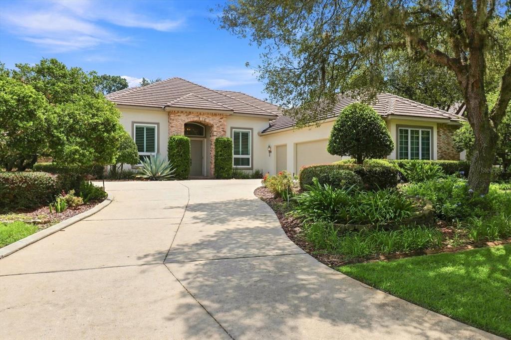 A single-story house with a concrete driveway, brick entryway, and a tiled roof — 3405 N SPYGLASS VILLAGE PATH, LECANTO, FL