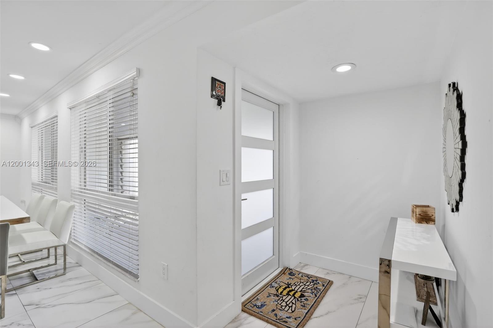 A bright entryway features white walls, marble-look tile floors, a modern door, and a console table — 9280 SW 55th Ct, Cooper City FL 33328, COOPER CITY, FL