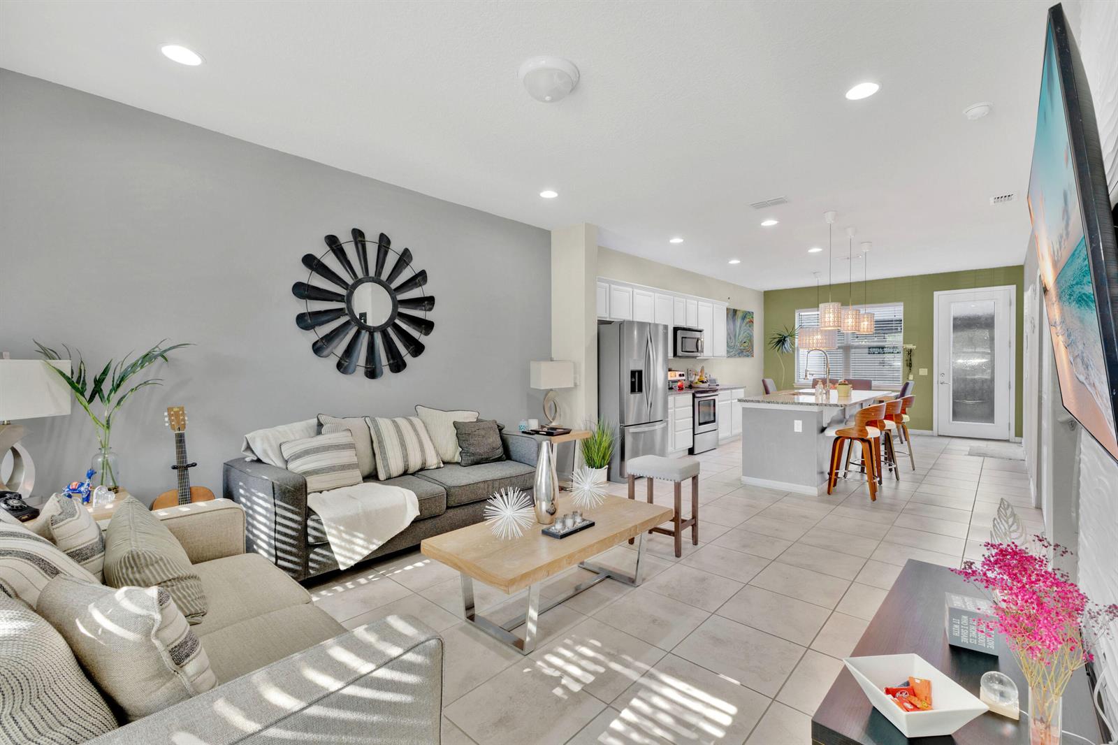 An open-concept living room and kitchen featuring gray walls, tile flooring, and a central island — 5120 Caspian Street, FL 34771, FL
