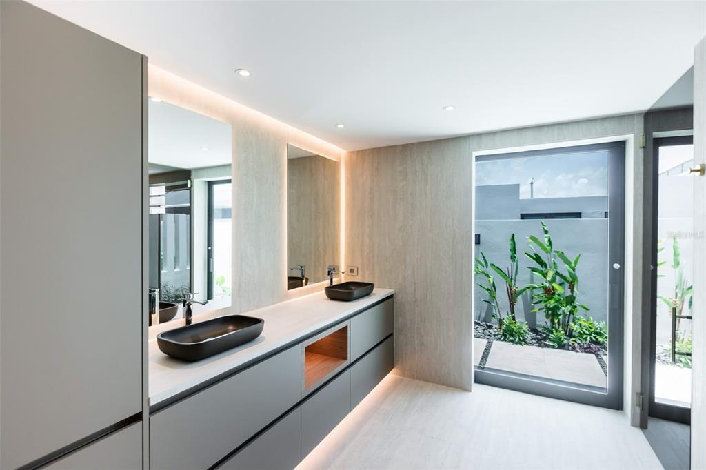 A modern bathroom features a double vanity with black vessel sinks and a glass door — RESIDENCES AT RIO CALLE EBRO CORNER UNIT 69, BAYAMON, PR