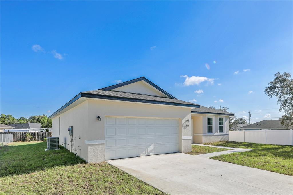 A single-story house with a white stucco exterior, a two-car garage, and a concrete driveway — 8539 SW 129TH LANE, OCALA, FL