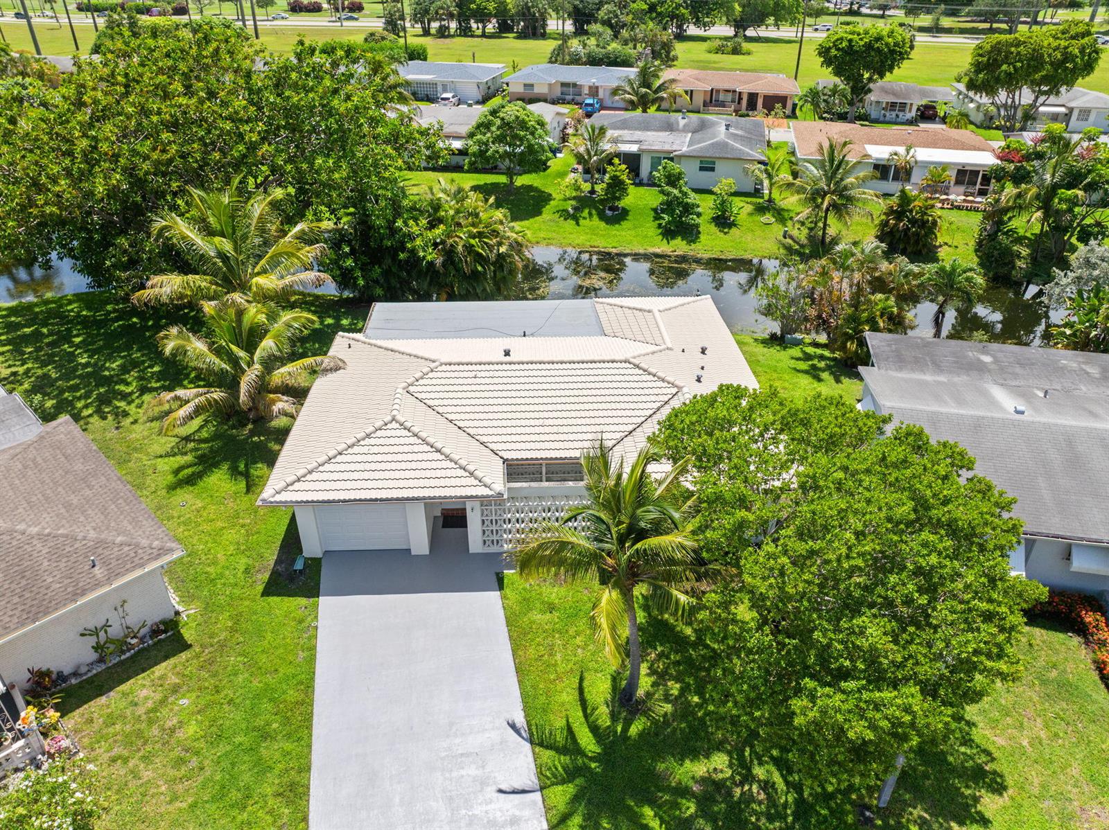 An aerial view shows a single-story house with a tiled roof and a concrete driveway — 1550 NW 70th Terrace, Margate FL 33063, MARGATE, FL