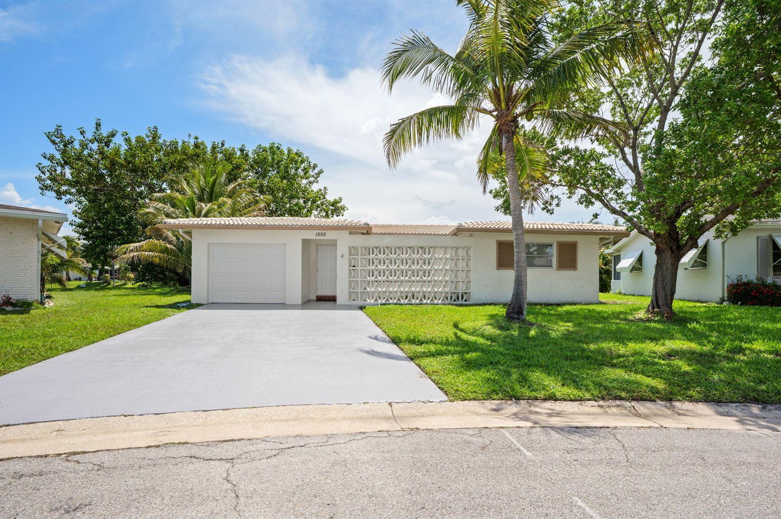 A single-story house with a white exterior, a garage, and a decorative concrete block wall — 1550 NW 70th Terrace, Margate FL 33063, MARGATE, FL