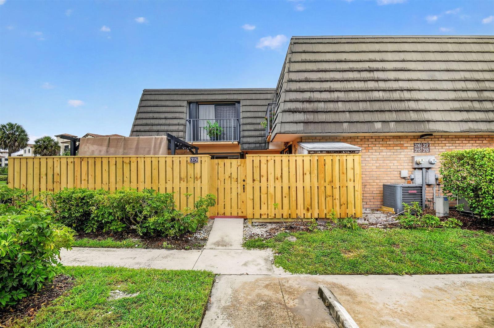 A two-story residential building with a wooden privacy fence and a small balcony — 315 3rd Way, West Palm Beach FL 33407, WEST PALM BEACH, FL