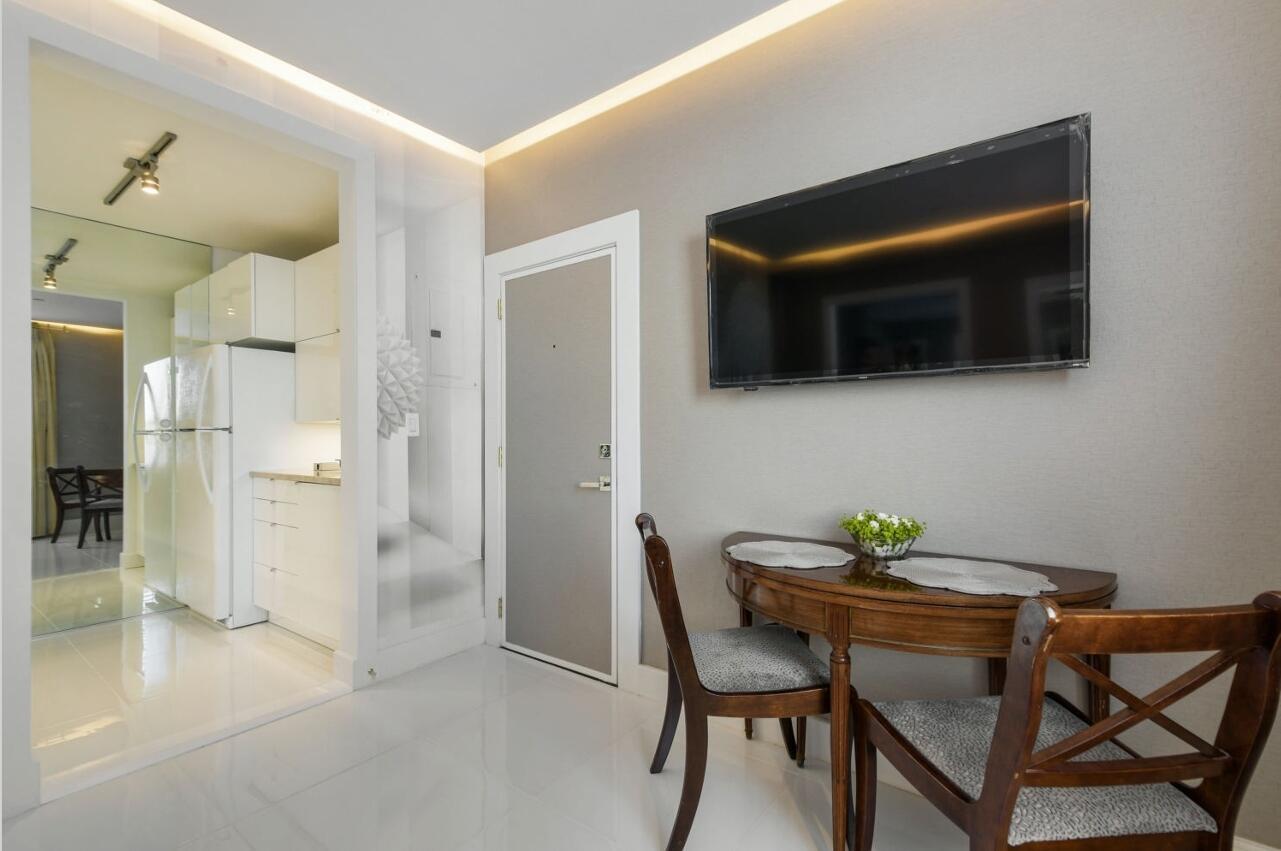 A small dining area with a wooden table, two chairs, and a wall-mounted television — 235 Sunrise Avenue # 2026, Palm Beach FL 33480, PALM BEACH, FL