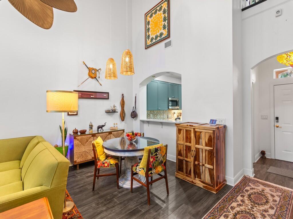 A living and dining area features a green sofa, a round table, and high ceilings — 1643 Baseline Lane, Vero Beach FL 32967, VERO BEACH, FL