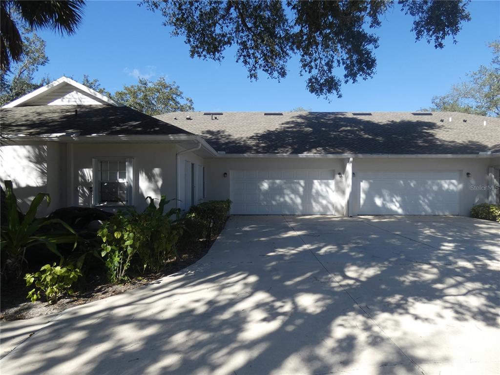 A single-story house exterior features a two-car garage and a concrete driveway — 1448 WINDING OAK DRIVE, PORT CHARLOTTE, FL