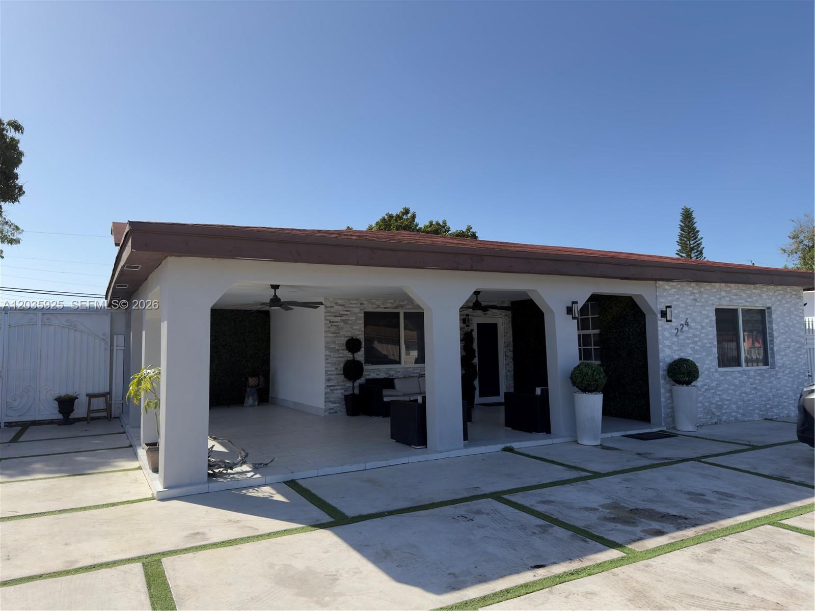 A single-story house features a covered patio with arched columns and a paved driveway — 224 E 42nd St, Hialeah FL 33013, HIALEAH, FL