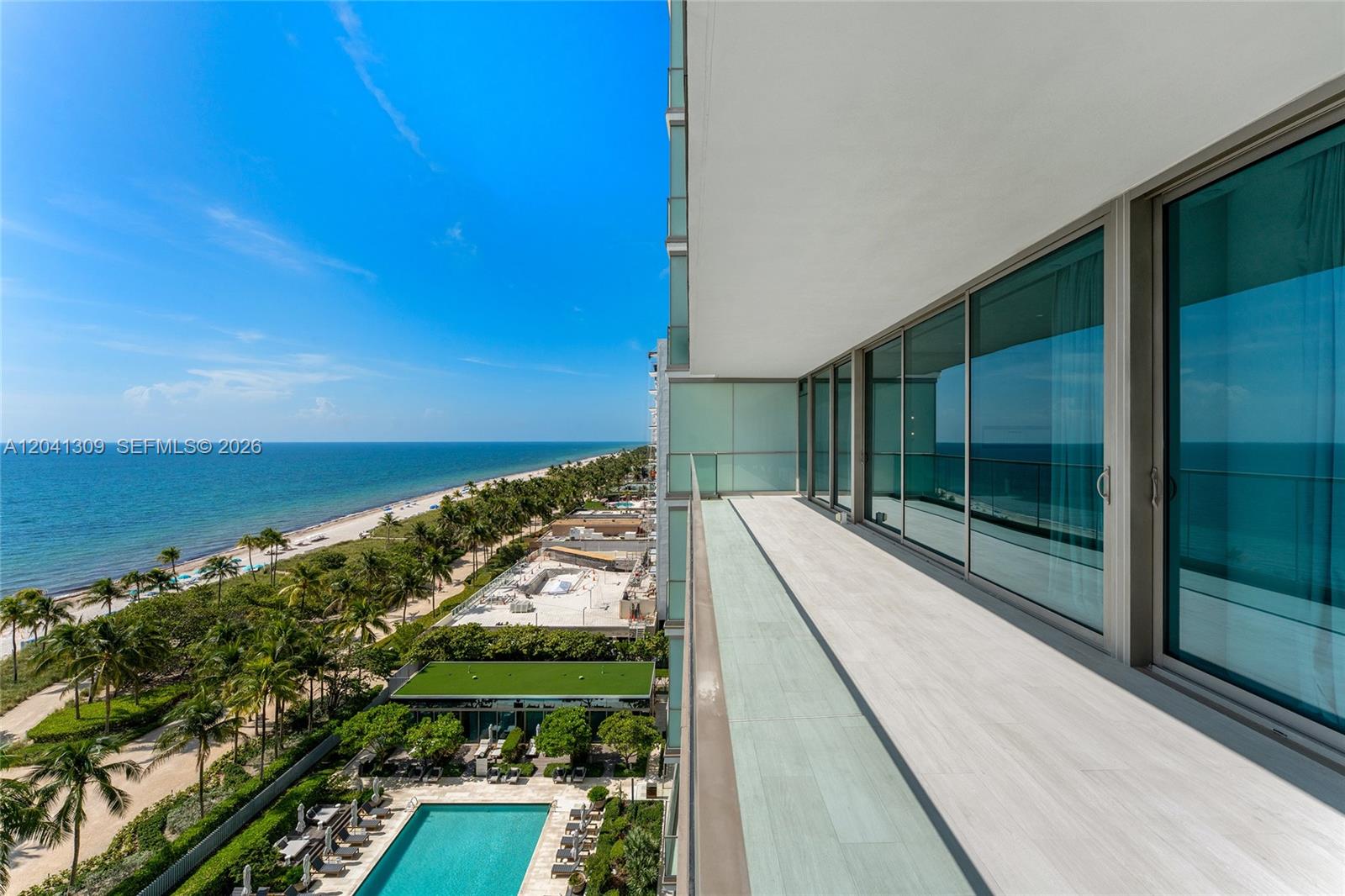 A high-rise balcony overlooks a swimming pool, palm trees, and the ocean — 10201 Collins Ave # 906, Bal Harbour FL 33154, BAL HARBOUR, FL
