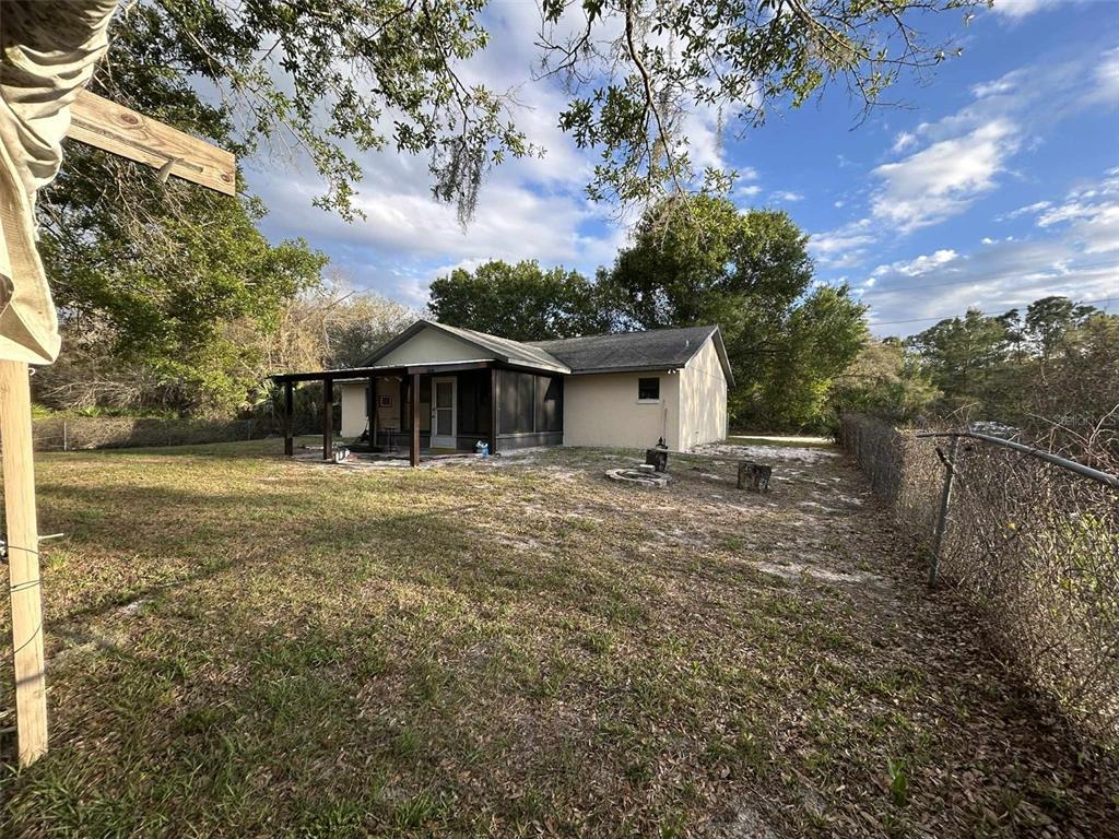 The exterior view shows a single-story house with a screened-in porch and a chain-link fence — 3137 CARLTON AVENUE, LAKE PLACID, FL