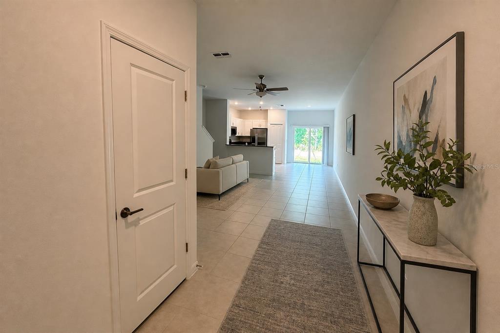 A tiled entryway leads into an open-concept living area with a kitchen and sliding doors — 17649 NECTAR FLUME DRIVE, LAND O LAKES, FL