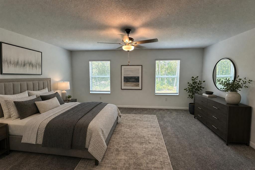 A bedroom features a gray upholstered bed, a dark wood dresser, and two windows — 17649 NECTAR FLUME DRIVE, LAND O LAKES, FL
