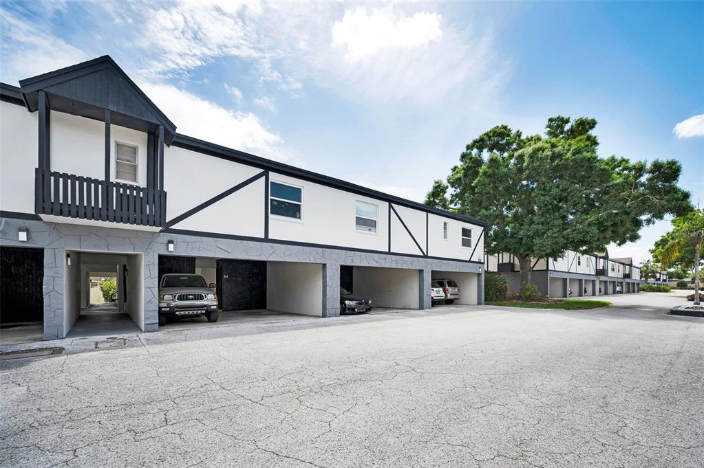 A two-story apartment building with covered parking spaces on the ground level — 1127 KING ARTHUR COURT UNIT 309, DUNEDIN, FL