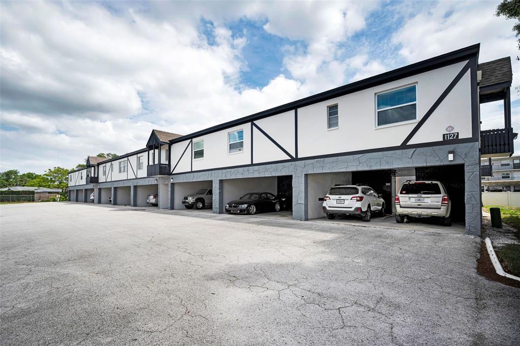 A two-story apartment building with covered parking spaces on the ground level — 1127 KING ARTHUR COURT UNIT 309, DUNEDIN, FL