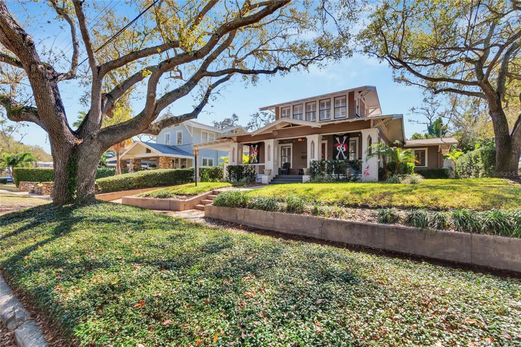 A brown bungalow with a front porch and dormer windows sits behind a terraced lawn — 3006 W HARBOR VIEW AVENUE, TAMPA, FL