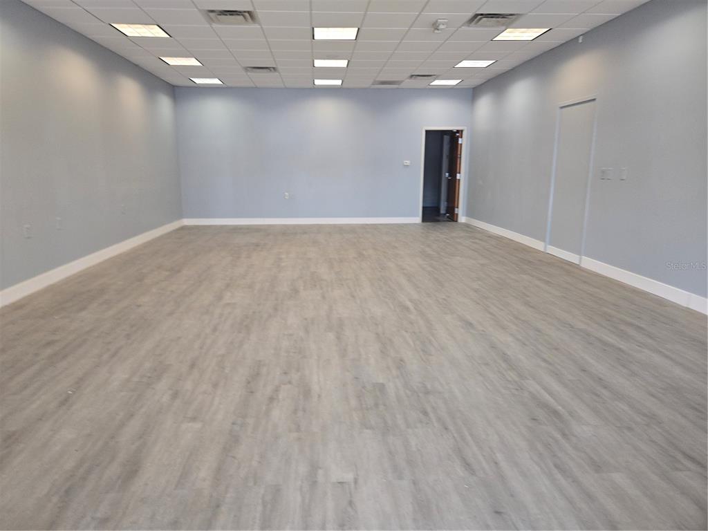 An empty office room features light gray walls, wood-look flooring, and a drop ceiling — 14202 N NEBRASKA AVENUE UNIT 14202, TAMPA, FL