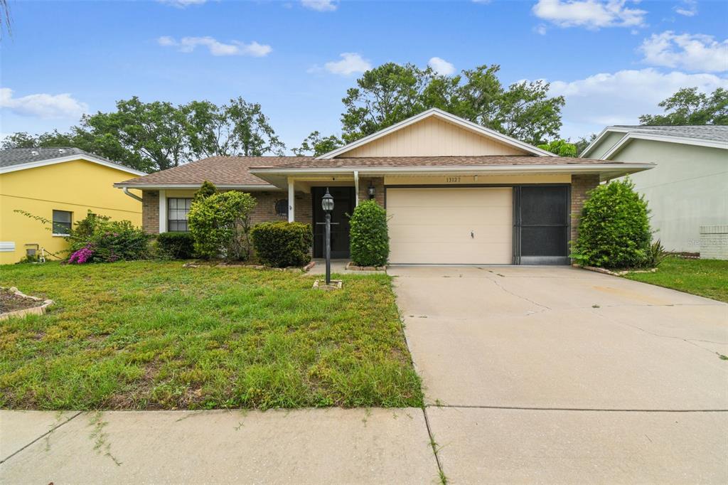 A single-story house with a brick facade, a two-car garage, and a front lawn — 13127 TOPFLITE COURT, HUDSON, FL