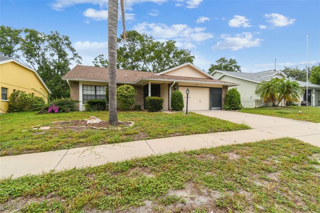 A single-story house with a brick and siding facade, a garage, and a front yard — 13127 TOPFLITE COURT, HUDSON, FL