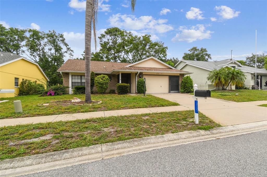 A single-story house with a beige exterior, a two-car garage, and a palm tree — 13127 TOPFLITE COURT, HUDSON, FL