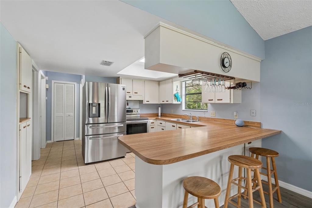 An elevated house with a white metal roof sits on a grassy lot near water — 1455 S OZELLO TRAIL, CRYSTAL RIVER, FL