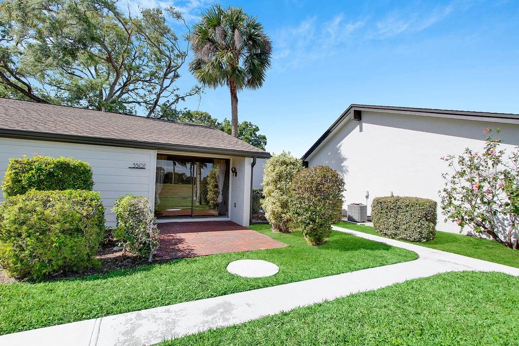 A brick patio sits in front of a sliding glass door at a residential home — 3507 LONGMEADOW UNIT 4, SARASOTA, FL