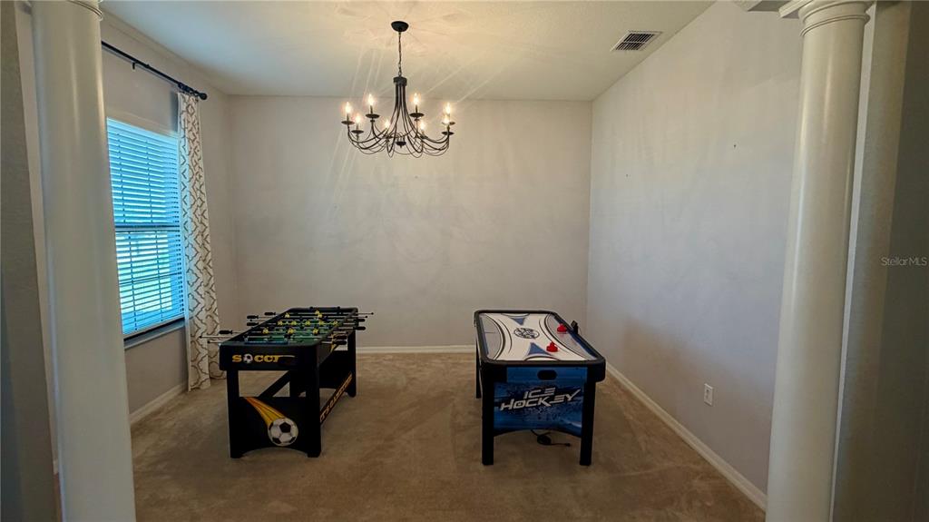 A carpeted room features a foosball table, an air hockey table, and a chandelier — 4046 DINNER LAKE WAY, LAKE WALES, FL