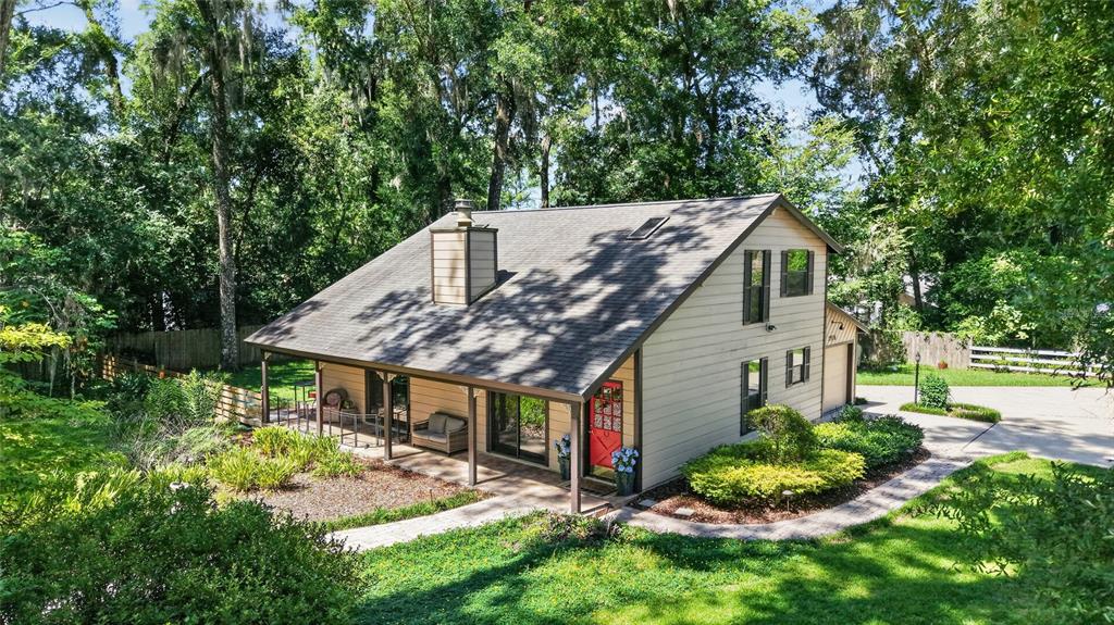 A two-story house with tan siding, a red front door, and a covered porch — 3936 SE 23RD TERRACE, OCALA, FL